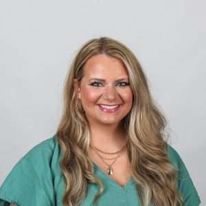 woman with blond hair green shirt blank background