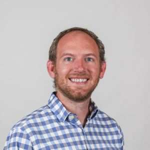 man with blond hair blue checkered shirt and blank background