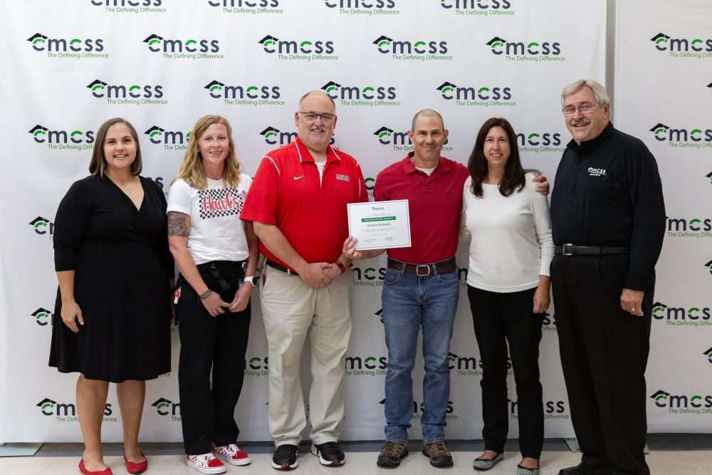 parents and athletic director accepting award