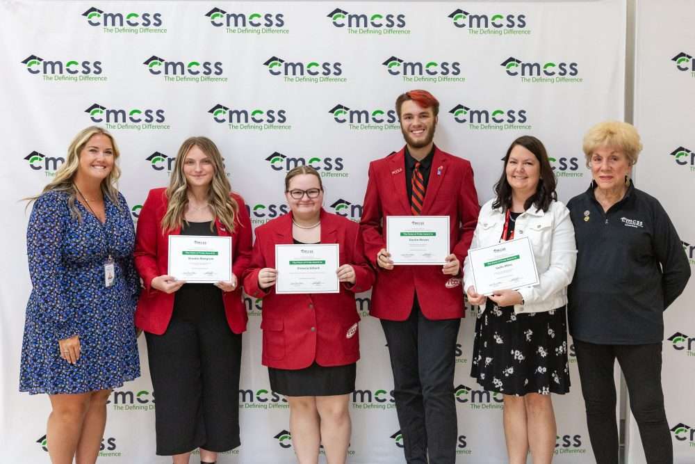 students in red coats receiving awards