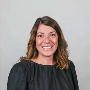 woman with brown hair black shirt blank background