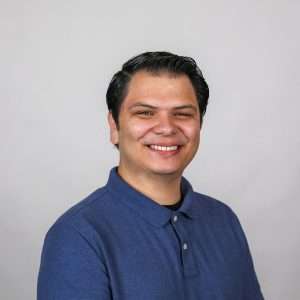 man with black hair blue shirt blank background