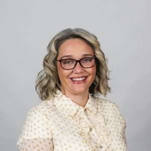 woman with blond hair white polka dot shirt blank background