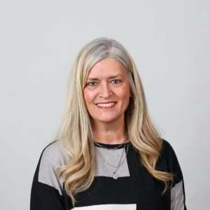 smiling woman with blond hair black shirt blank background