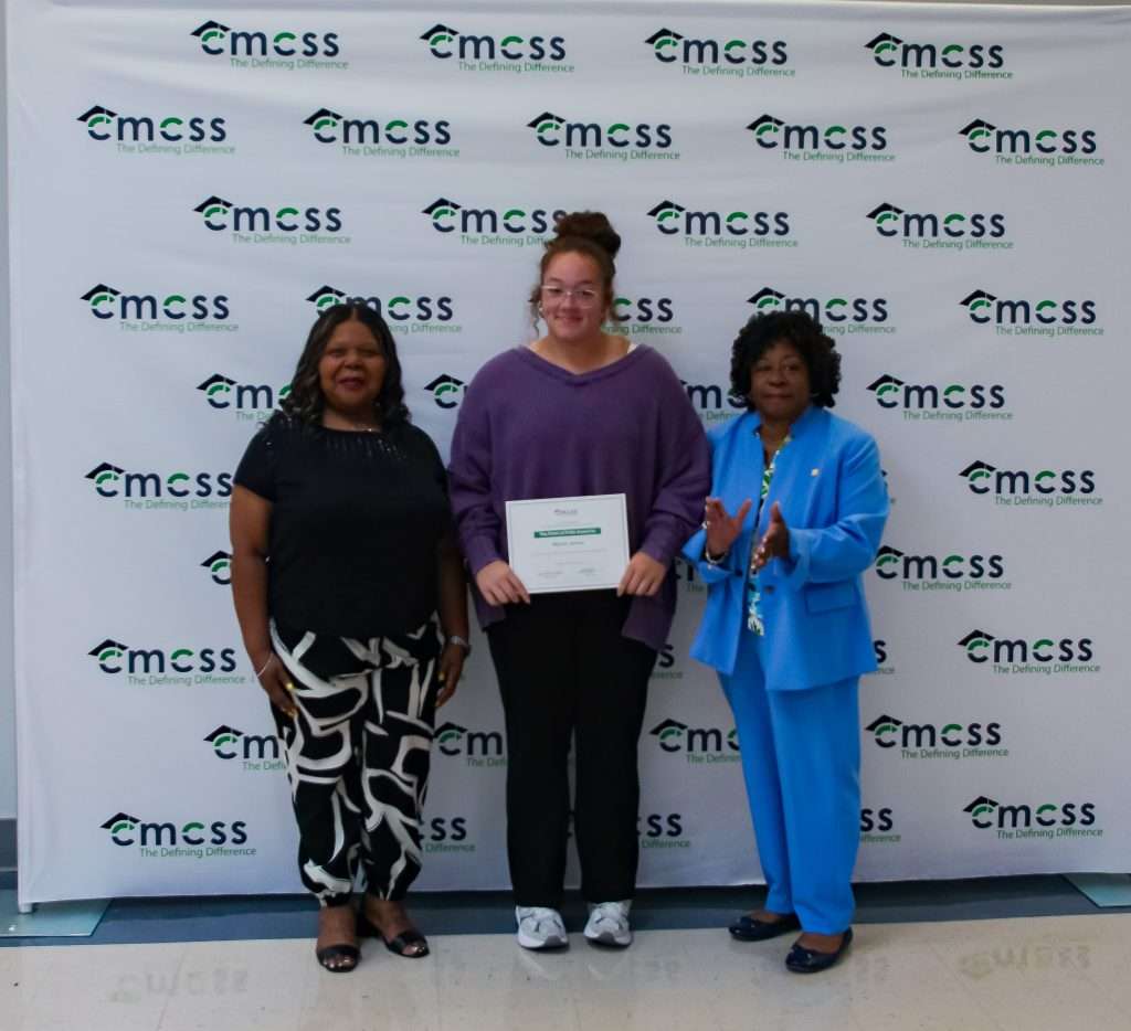 three females posing with award