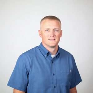 male smiling wearing blue shirt in front of blank background