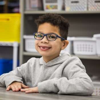 kindergarten boy at desk wearing glasses