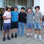 Group of five male students outside of car dealership
