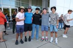 Group of five male students outside of car dealership