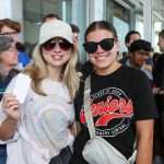 two female students with a gift card wearing sunglasses
