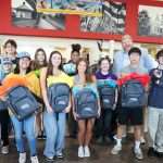 top ten students at Pass and Go event smiling holding backpacks