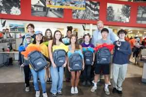 top ten students at Pass and Go event smiling holding backpacks