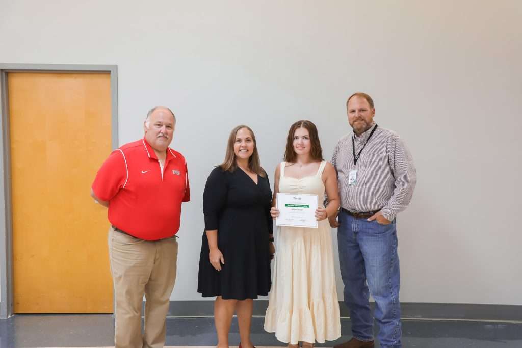 four people displaying award