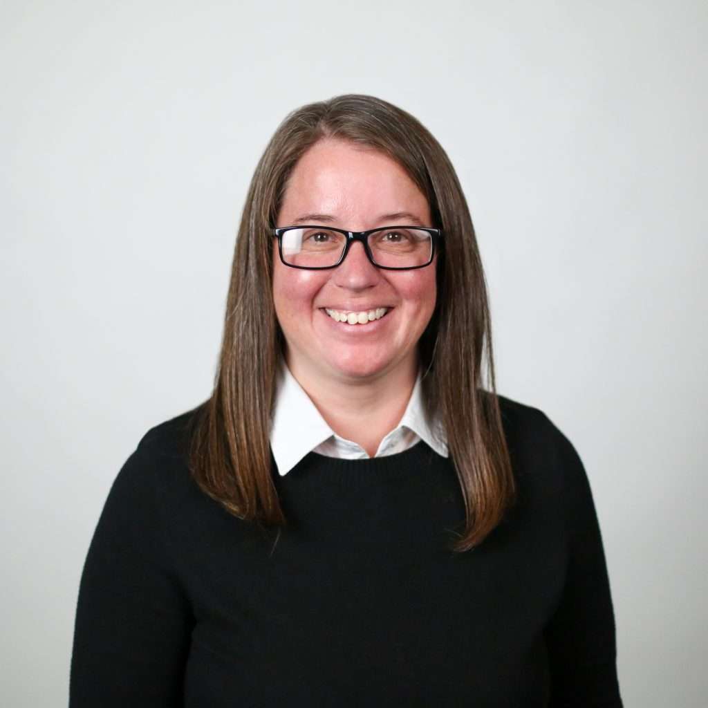 woman with brown hair wearing glasses and a black sweater