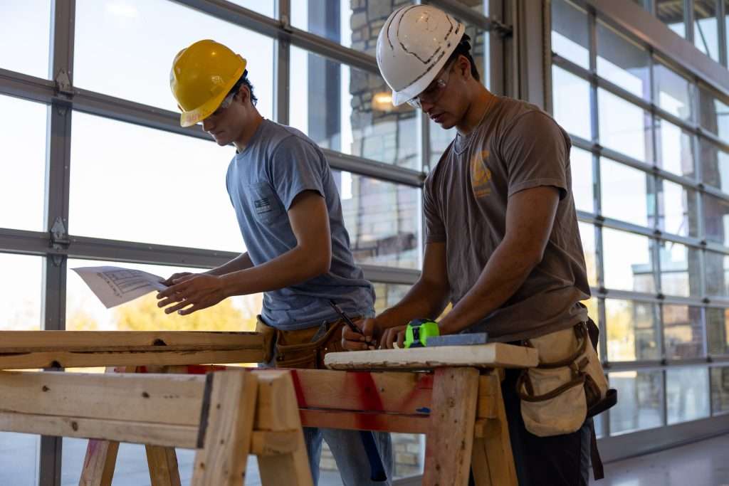 Two male students working on a construction project
