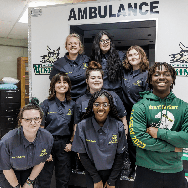 Group of high school students in front of ambulance simulator