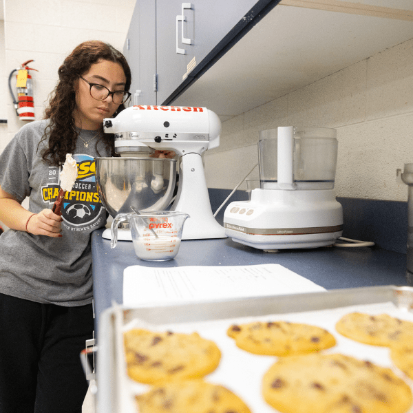 girl standing by counter with cookies