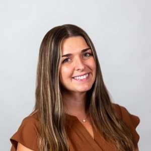 Headshot of Hailey Fisher (brown haired woman in brown shirt)