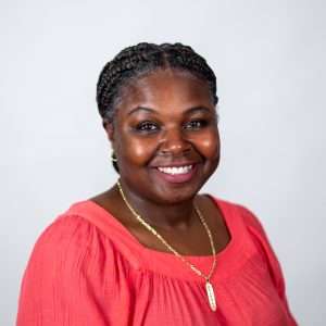 Headshot of Atiyyah Minor (dk brown hair and orange shirt)