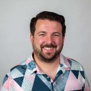 Headshot of Frank Rose (man with brown hair and colorful shirt)