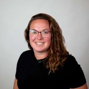 Headshot of Connie Castleman (red haired woman in black shirt)
