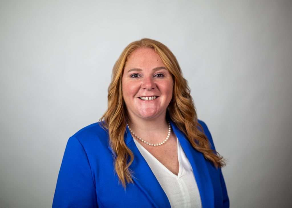 woman blue jacket white shirt smiling